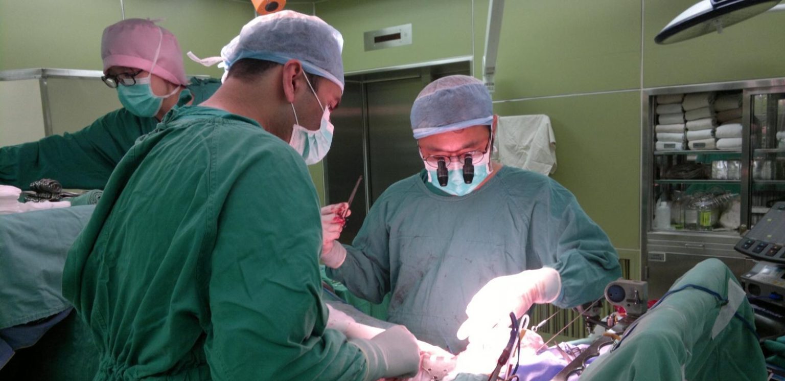 Surgeons performing complex procedure in operating room
